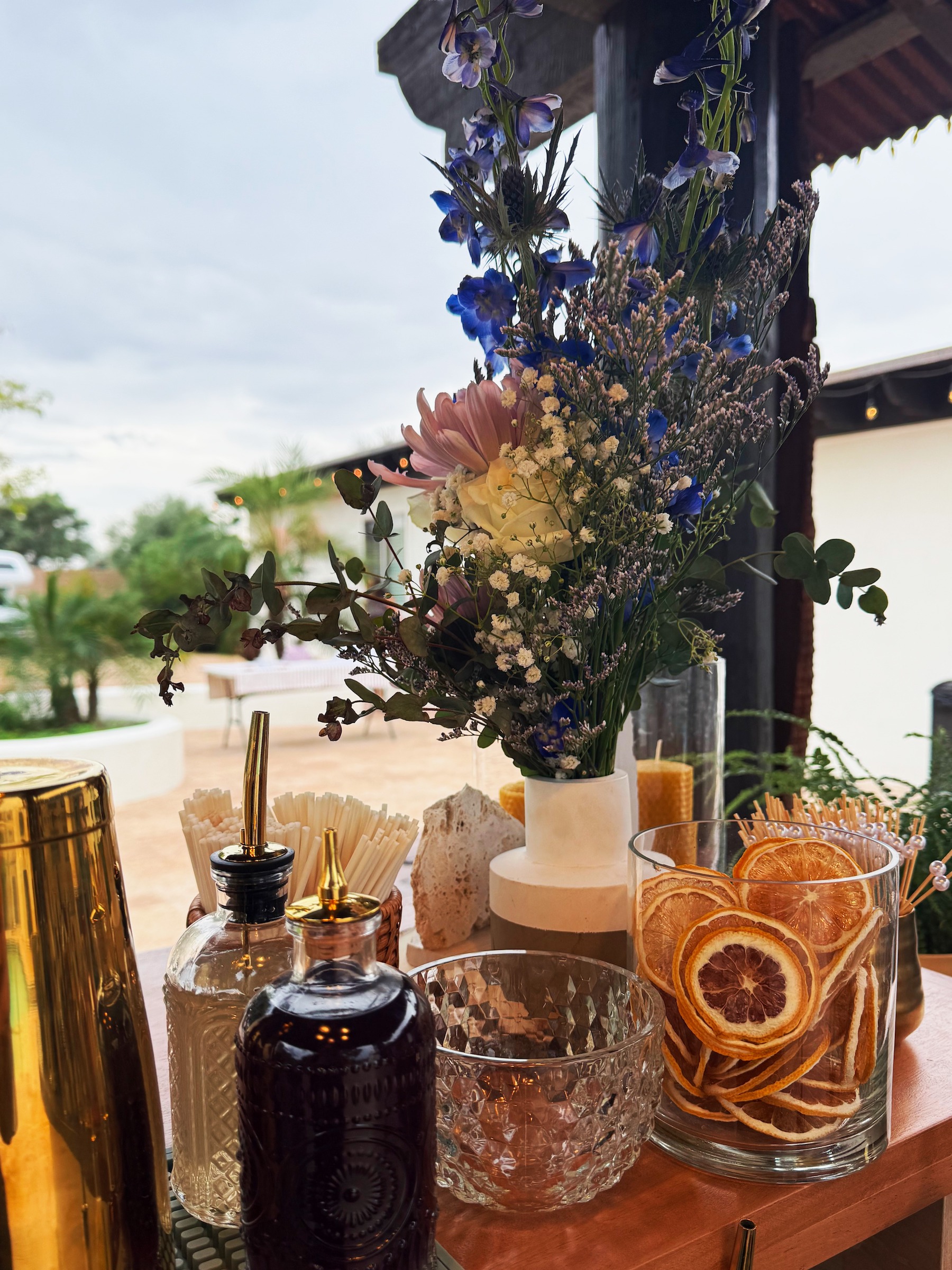 Close-up of a luxury mobile bar garnish station featuring dried citrus wheels, artisanal cocktail syrups, and fresh floral arrangements for a private event in Arizona.