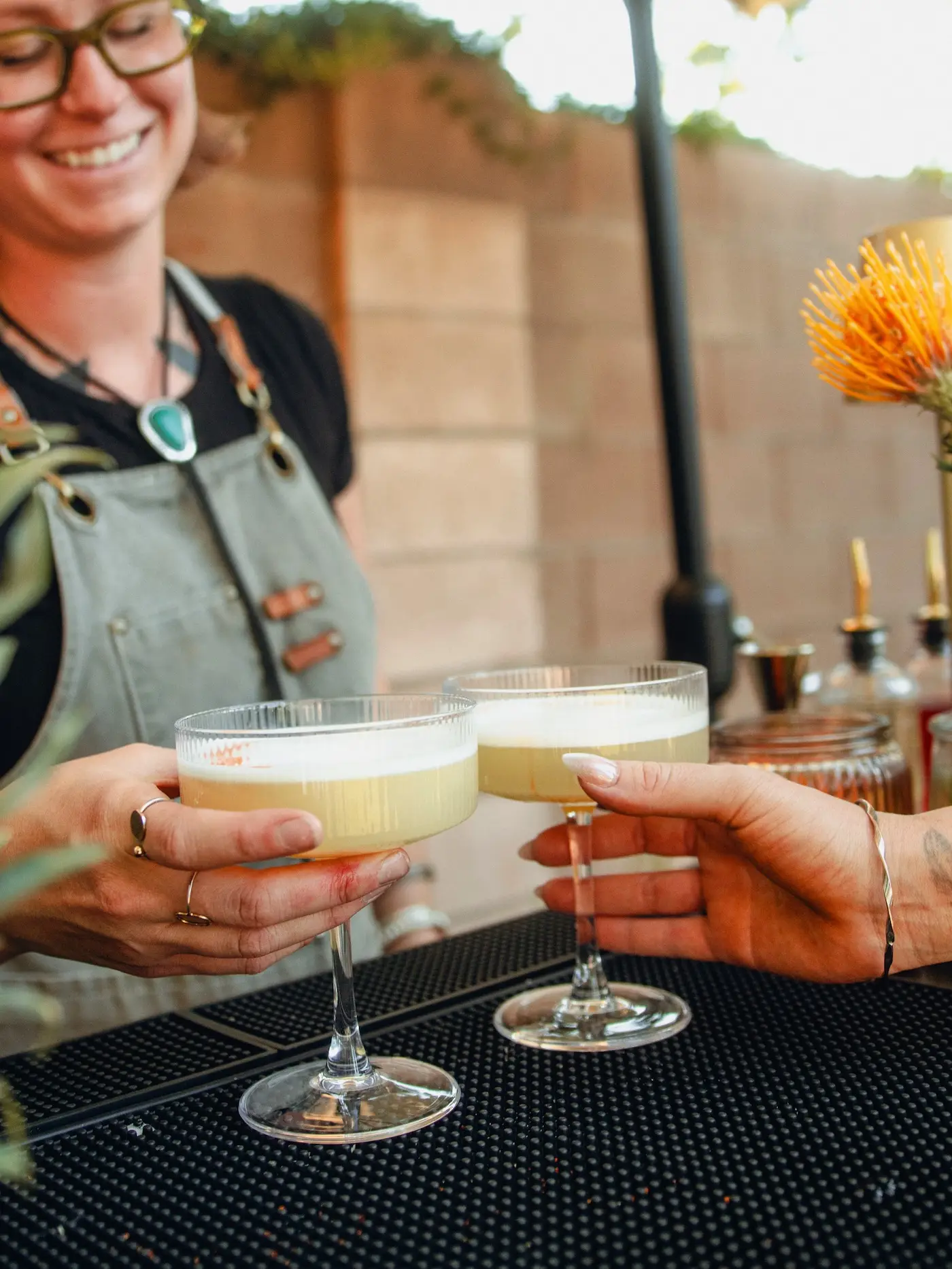 Professional Arizona bartender serving a custom craft cocktail at a private outdoor event.